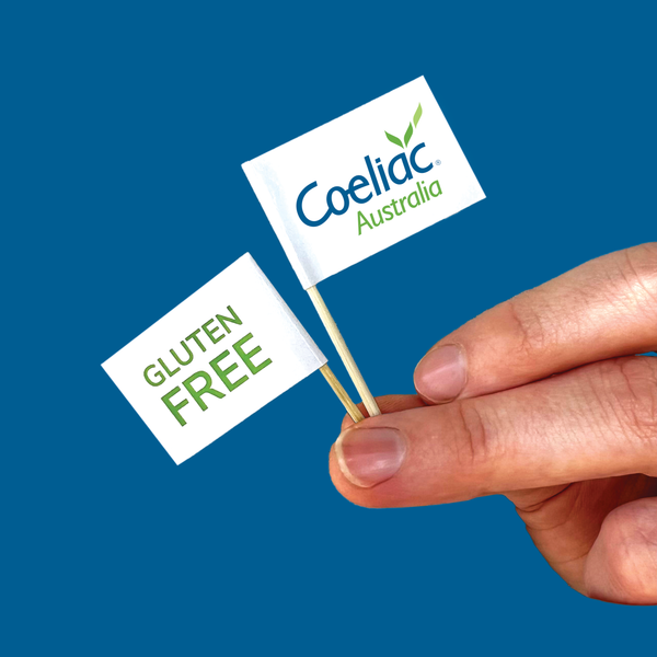 White flag attached to a toothpick featuring Coeliac Australia logo on one side and the wording 'GLUTEN FREE' in bright green on the other.